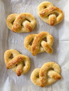 four pretzels are arranged in the shape of an interlocked knot on a piece of parchment paper