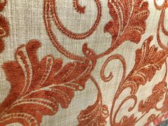 an orange and white fabric with ornate designs on it's edges, close up