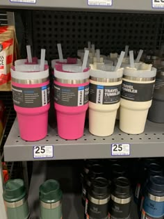 there are many cups on the shelf in this grocery store, each with different colors