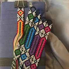 a pair of scissors are on a piece of fabric with beadwork and tassels