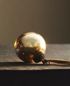 a glass ball sitting on top of a wooden table next to a metal object with a cord