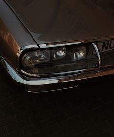 the front end of a brown car with headlights