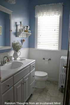 a bathroom with blue walls and white fixtures