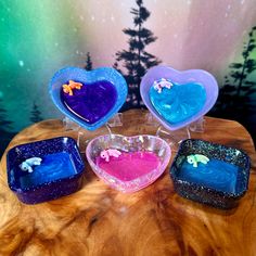 four heart shaped soaps sitting on top of a wooden table