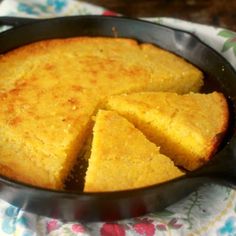 a skillet filled with cornbread on top of a table