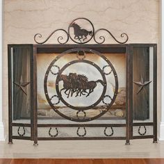 an iron fireplace screen with horses on it