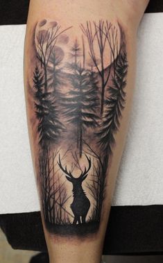 a man's arm with a deer and trees tattoo on the left side of his leg