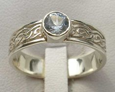 a white gold ring with a blue topazte stone in it's center