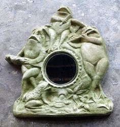 a green statue with a mirror in the shape of a fish and turtle on it