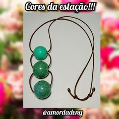 three green beads are hanging from a brown cord with the words coros da estacao