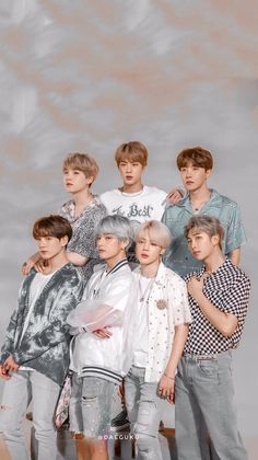 the group of young men are posing together for a photo in front of a gray background