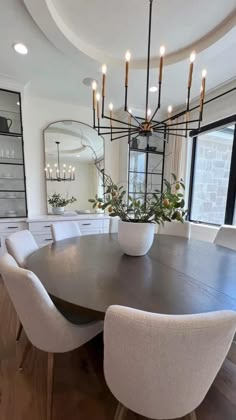 a dining room table with white chairs around it