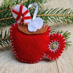 an ornament made to look like a coffee cup with a candy cane on top