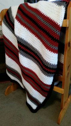 a crocheted blanket sitting on top of a wooden chair