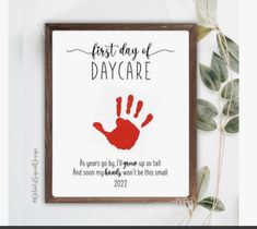 a handprinted poster with the words first day of day care on it and a plant next to it