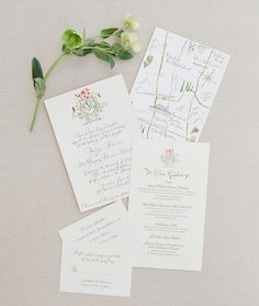 the wedding stationery is laid out on top of each other with flowers and greenery