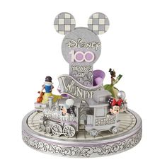 mickey mouse's 100th anniversary figurine with train and characters on it