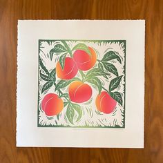 a print of peaches on a white paper with green leaves and brown wood background