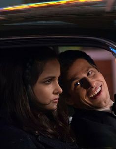 a man and woman sitting in the back of a car