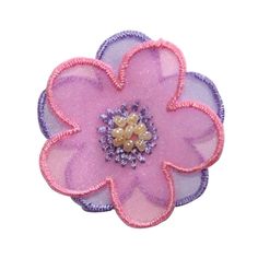 a pink and purple flower with pearls on it's center, sitting in front of a white background