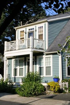 a blue house with white trim and balconies