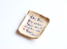 a small ceramic dish with writing on it