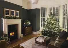 a living room filled with furniture and a christmas tree in front of a fire place