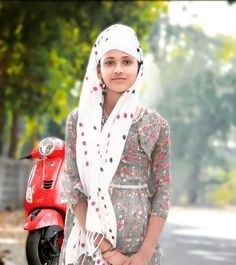 a woman standing next to a red scooter