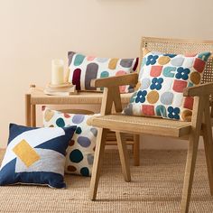 two wooden chairs sitting next to each other on top of a carpeted floor in front of a wall