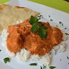 some food is on a white plate with green garnishes and sauces