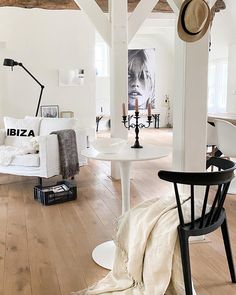 a living room filled with white furniture and lots of wood flooring on top of it