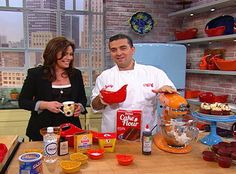 a man and woman standing in front of a table full of food on the set of tv show good morning america