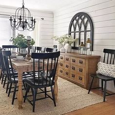 the dining room table is set with black chairs and an old dresser in front of it