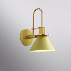 a wall light with a yellow shade on it's side and a white background