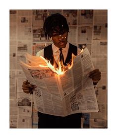 a man reading a newspaper with flames coming out of his face and hands behind him