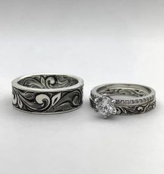 two wedding rings with diamonds on them sitting next to each other in front of a white background