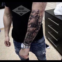 a man with a ship tattoo on his arm