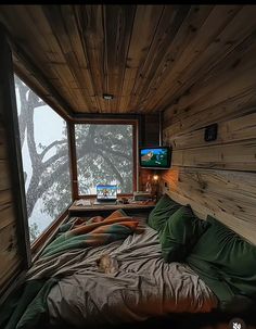 a bed in a room next to a window with a tv on top of it