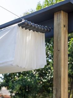 a white curtain hanging from the side of a wooden structure