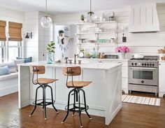 a kitchen with two stools and an island