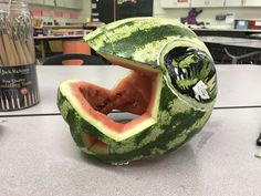 a watermelon carved to look like a snake with its mouth open