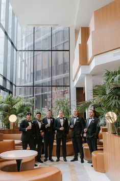 a group of men standing next to each other in front of a tall glass building