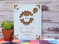 a happy birthday card with a sheep on it next to a potted succulent