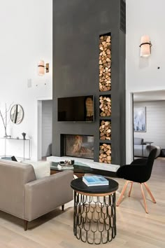 a modern living room with wood stacked on the wall and fireplace in the center area