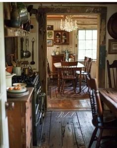 an old fashioned kitchen and dining room with wood floors