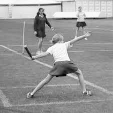 three women playing tennis on an outdoor court