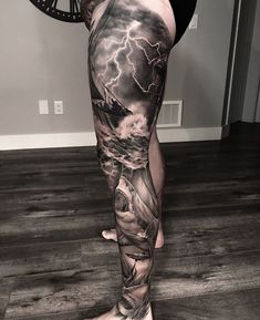 a person with a tattoo on their leg standing in front of a clock and lightning