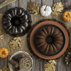 chocolate bundt cake surrounded by fall decorations and pine cones on a wooden table top