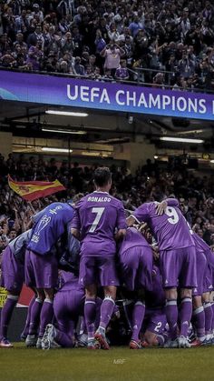 a group of soccer players huddle together on the field