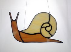 a stained glass hanging light with a snail on it's back and two strings